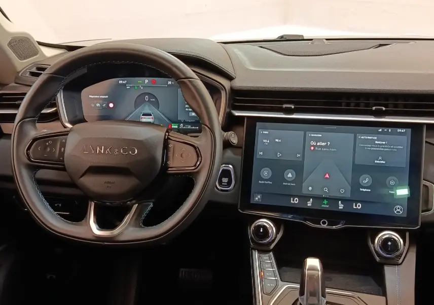 Vue intérieure centrée sur le volant cuir noir et l’écran tactile central du tableau de bord du Lynk & Co 01 hybride.