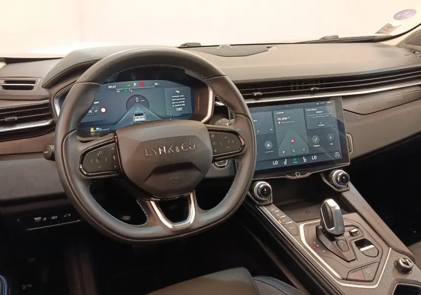 Vue intérieure centrée sur le volant et la console centrale tactile du Lynk & Co 01, finition noire moderne.