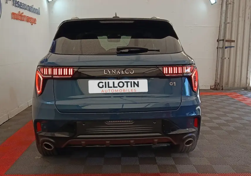 Vue arrière du SUV bleu LINK & CO 01 avec feux LED distinctifs et double sortie d’échappement en intérieur.