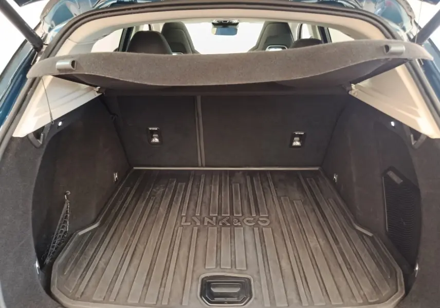 Vue intérieure du coffre ouvert du Lynk & Co 01 bleu, avec tapis de protection marqué Lynk & Co.