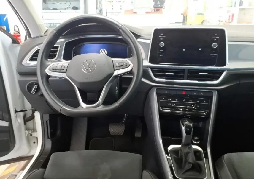 Vue intérieure frontale du tableau de bord du Volkswagen T-Roc 2.0 TDI 150CH Style 2022 avec volant multifonction et écran tactile central.