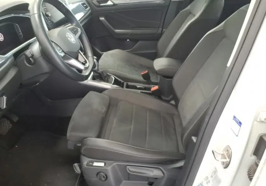 Vue intérieure côté conducteur du Volkswagen T-Roc 2022, sièges noirs en tissu et cuir, volant multifonction et tableau de bord moderne.