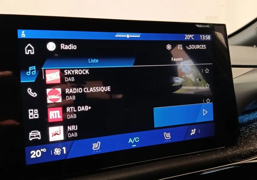 Écran tactile central de la Renault Clio Techno TCe 115 gris foncé, affichant les stations radio DAB.