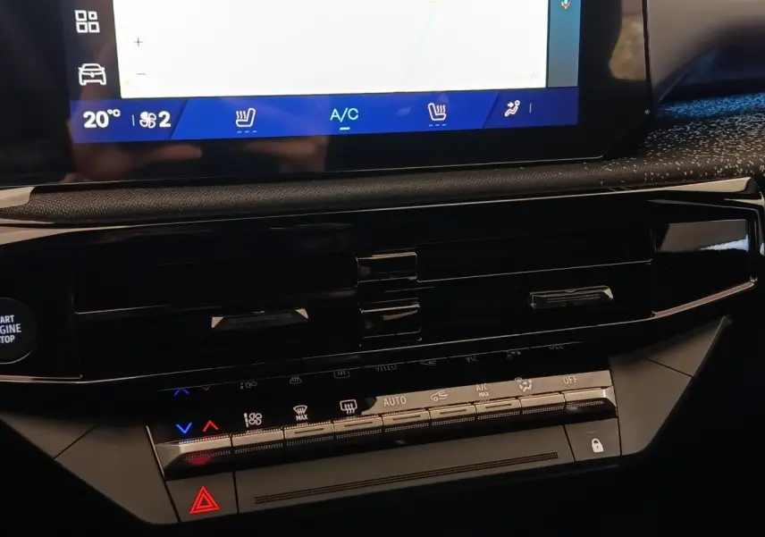 Détail du tableau de bord central de la Renault Clio Techno TCe 115 gris foncé avec écran tactile et commandes climatisation.