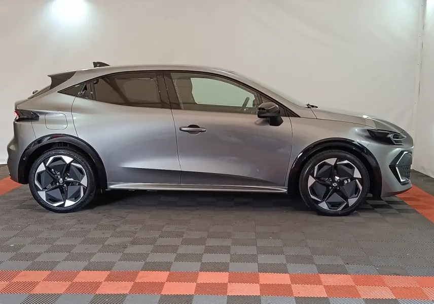 Profil droit de la Renault Clio Techno TCe 115 gris foncé avec jantes noires et détails noirs brillants.