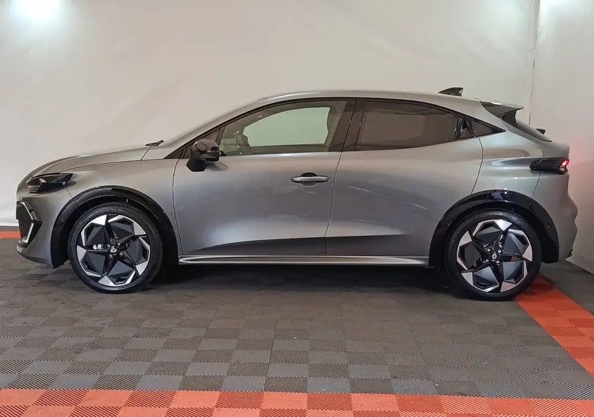 Profil droit de la Renault Clio 2026 gris foncé avec jantes noires et détails de carrosserie modernes.