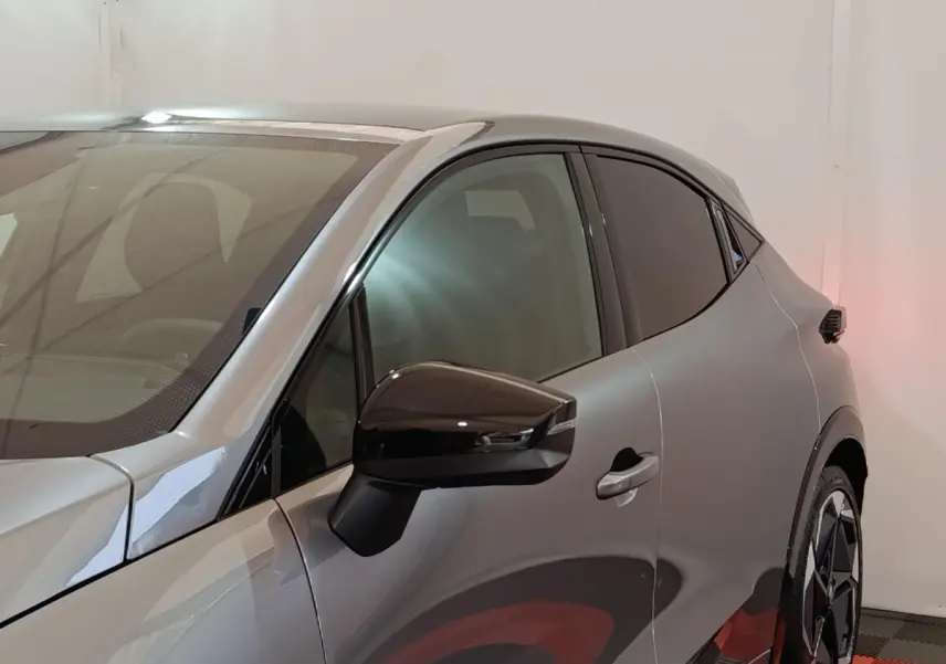 Vue de profil côté gauche sur une Renault Clio Techno TCe 115 essence gris foncé avec rétroviseur noir brillant.