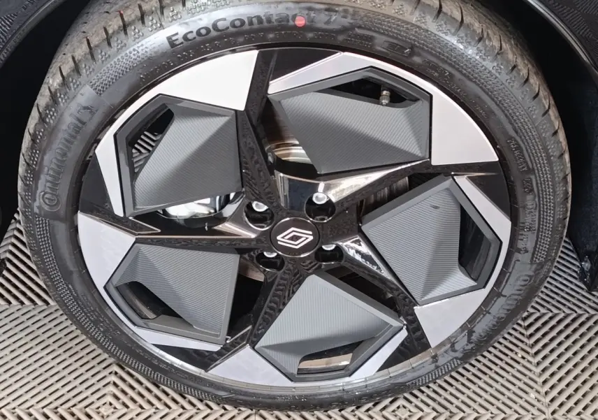 Gros plan sur la jante noire et grise au design géométrique de la Renault Clio Techno TCe 115 2026 gris foncé.
