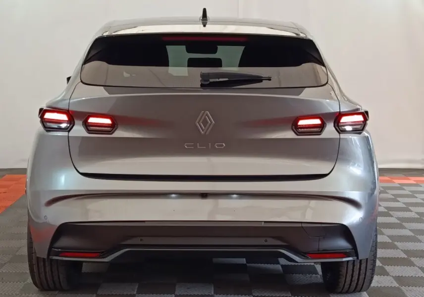 Vue arrière d’une Renault Clio gris foncé 2026 avec feux arrière LED allumés et lunette arrière teintée.