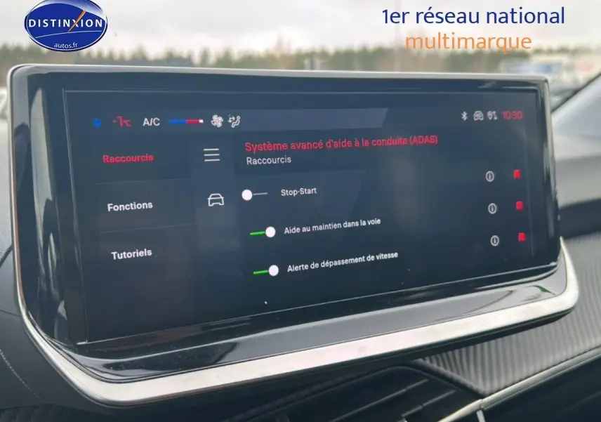 Écran tactile du système d’aide à la conduite dans l’habitacle d’une Peugeot 208 gris artense, vue de face.