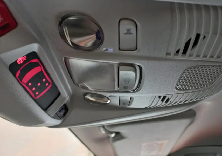 Vue en gros plan du plafonnier gris clair avec commandes d'éclairage et alerte ceinture dans un Peugeot 5008 gris foncé.