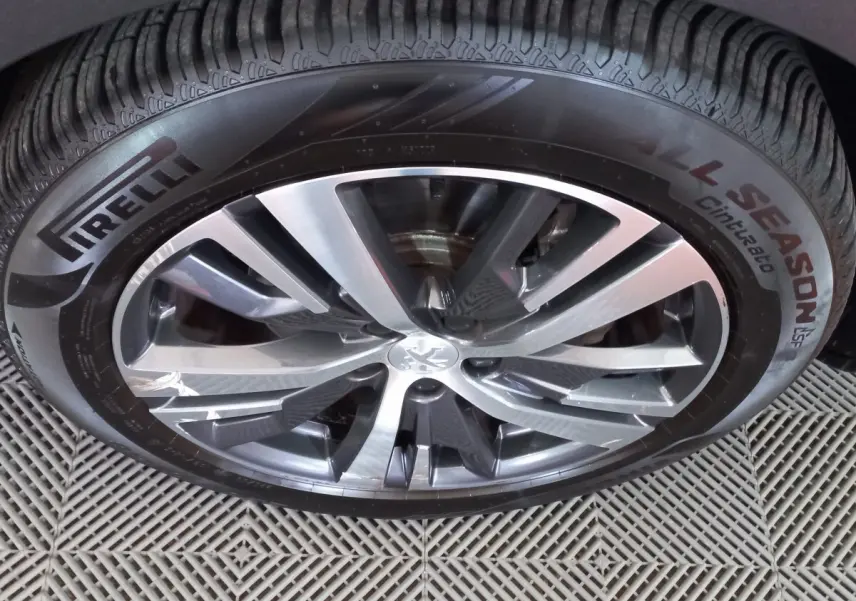 Gros plan sur la jante alliage et pneu Pirelli All Season du Peugeot 5008 gris foncé, détail de la roue avant.