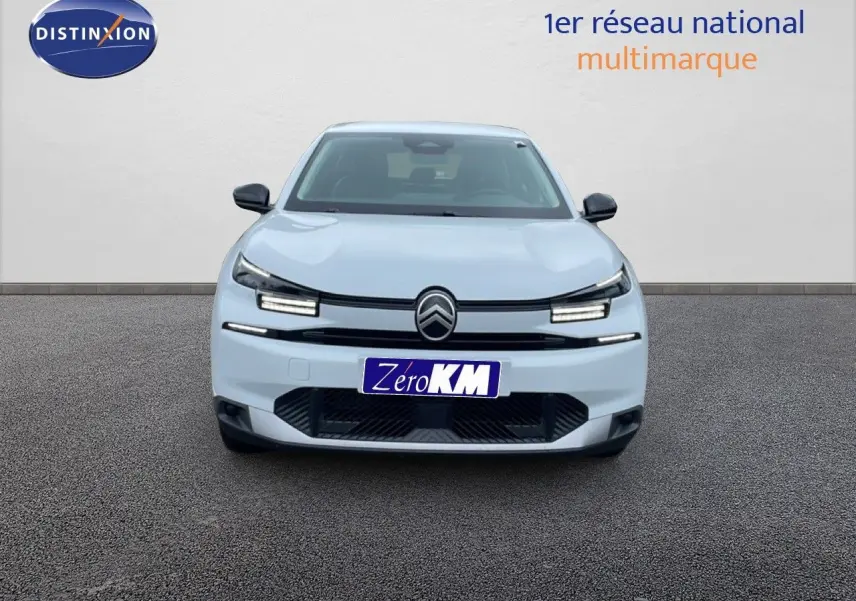 Vue frontale d'une Citroën C4 blanche métal avec phares LED allumés sur fond neutre.