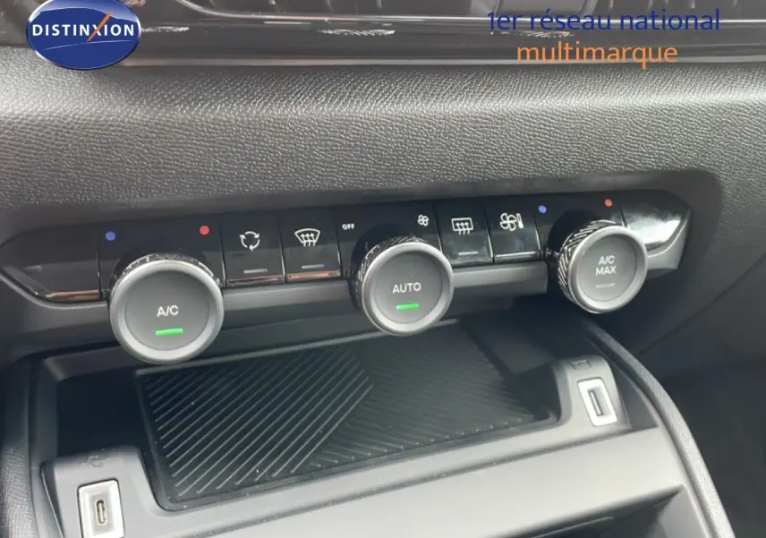 Détail de la console centrale de la Citroën C4 blanc métal, montrant les commandes de climatisation automatique et les ports USB.