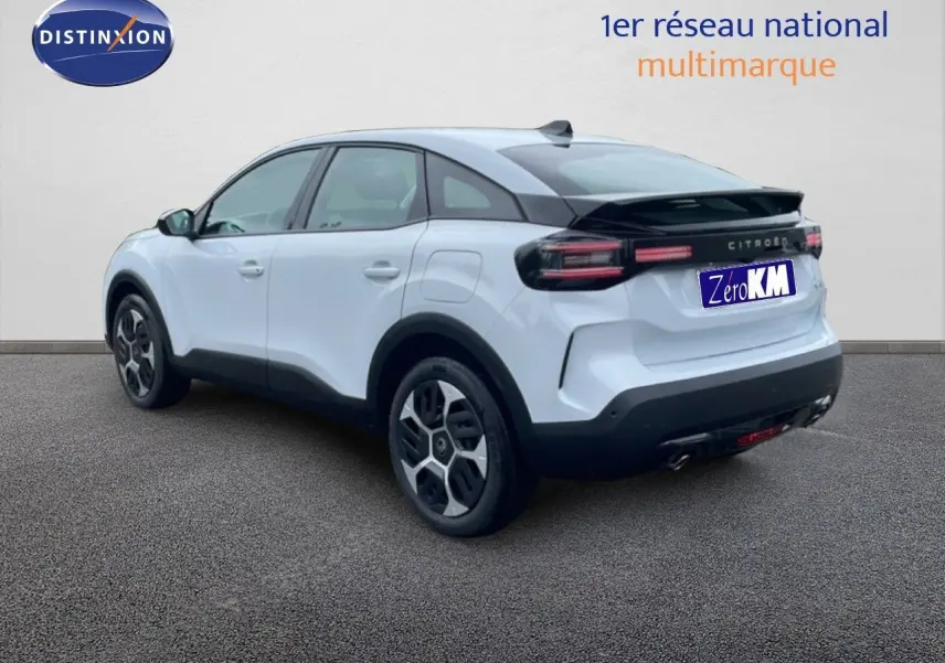 Vue 3/4 arrière droite d'une Citroën C4 blanche métal avec toit noir et feux arrière horizontaux LED.