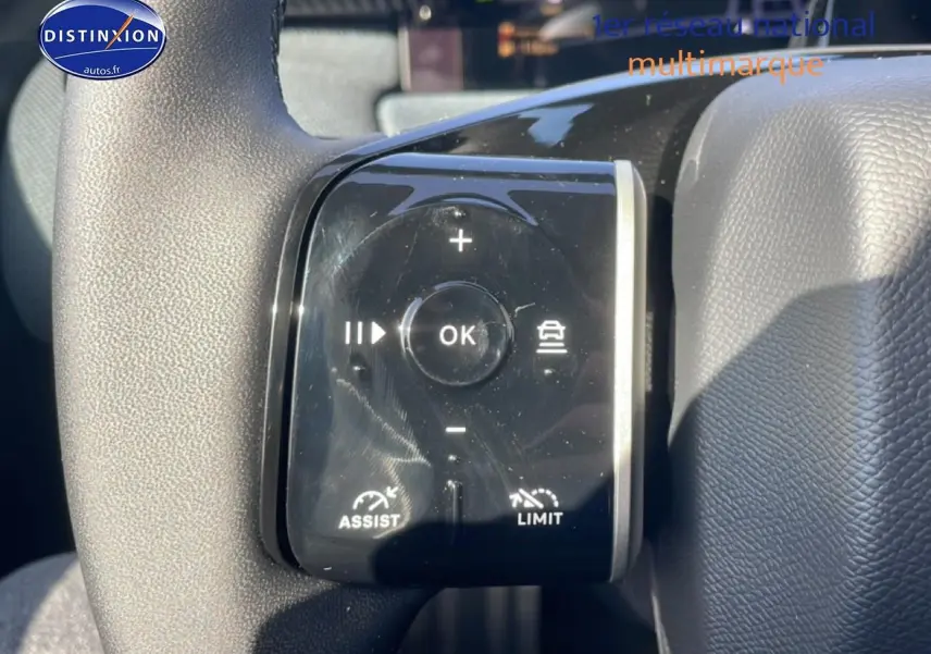 Gros plan sur les commandes noires du volant multifonction du Citroën C5 Aircross blanc, version hybride 2026.