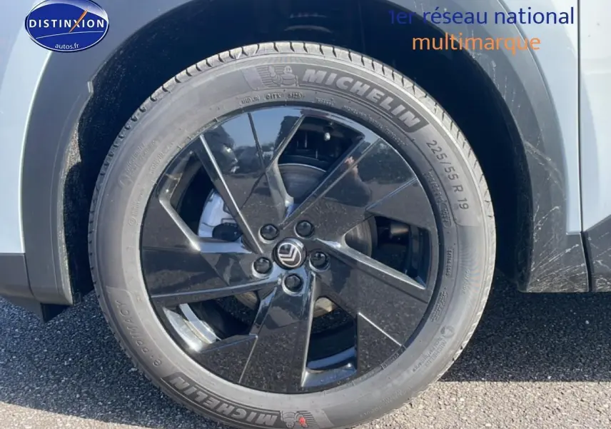Gros plan sur la roue arrière droite noire à jante 19 pouces du Citroën C5 Aircross blanc 2026 hybride.