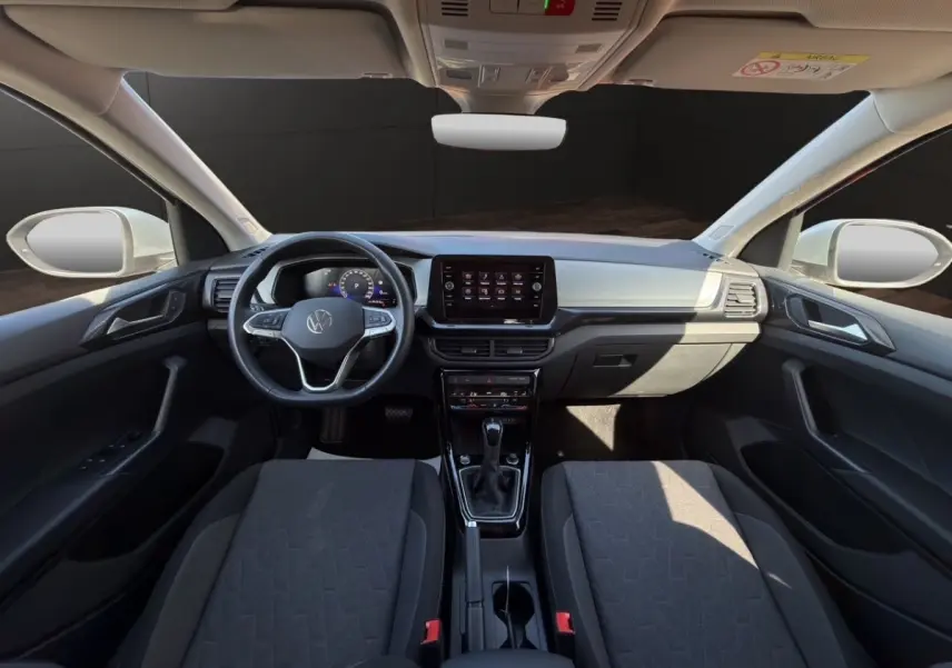 Vue intérieure frontale du tableau de bord et volant cuir alu du Volkswagen T-Cross 2025 avec écran tactile central.