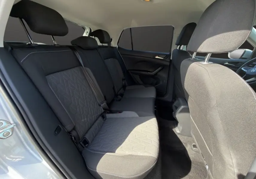 Vue intérieure côté droit montrant la banquette arrière grise du Volkswagen T-Cross 2025 avec tissu texturé.