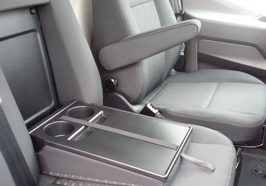 Vue rapprochée de l'intérieur côté passager du Ford Transit Fourgon 2022, sièges gris avec accoudoir et porte-gobelets.