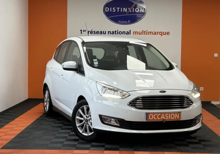 Vue 3/4 avant d'une Ford C-MAX blanche 2018 avec calandre chromée et jantes alliage 16 pouces en intérieur showroom.