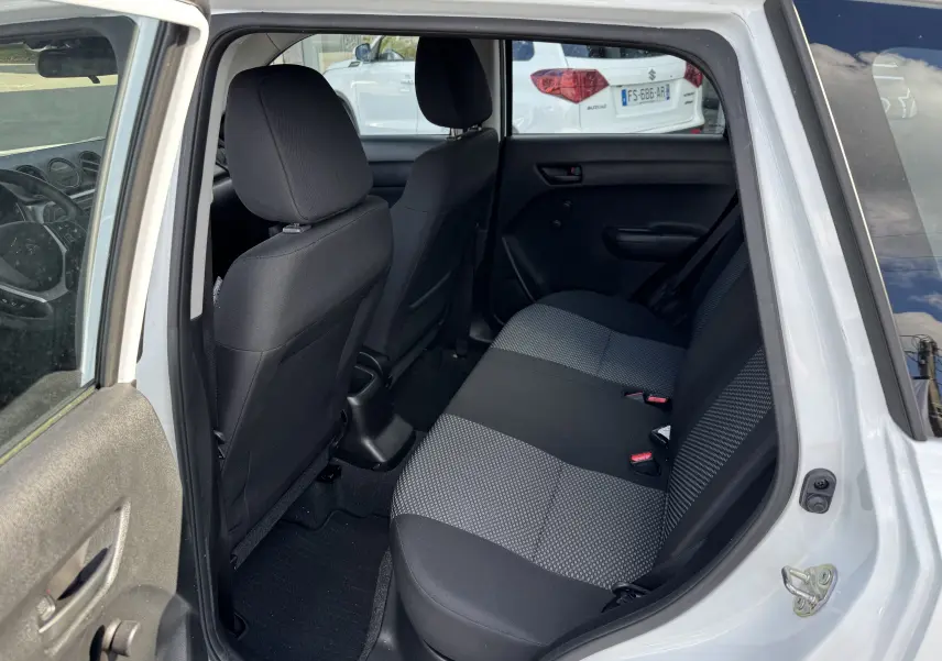 Vue intérieure arrière côté gauche du Suzuki Vitara blanc 2023, montrant les sièges arrière en tissu bicolore noir et gris.