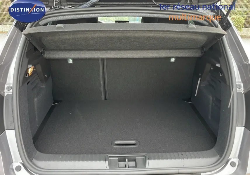 Coffre ouvert du Renault Captur E-Tech hybride 2025 en gris Cassiopée métal avec intérieur noir, vue arrière.