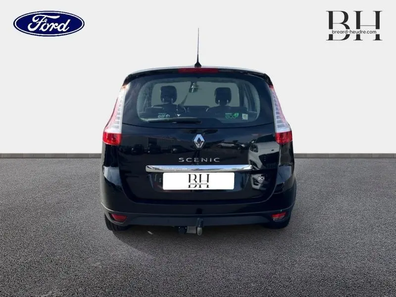 Vue arrière d'un Renault Grand Scenic noir étoilé avec feux verticaux et attelage visible sur sol gris.