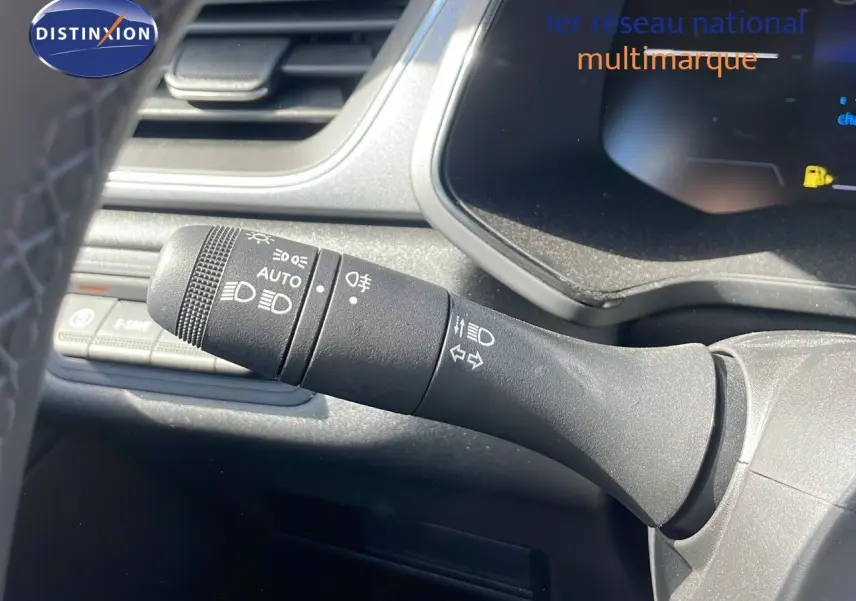 Gros plan sur la commande des phares et clignotants du Renault Captur E-Tech hybride 2025, intérieur noir.