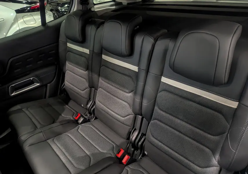 Vue intérieure sur la banquette arrière en cuir noir et tissu gris du Citroën C5 Aircross hybride 2025.