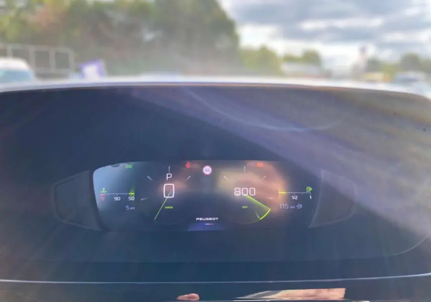 Tableau de bord numérique de la Peugeot 308 2025 affichant la vitesse, régime moteur et jauges, vue frontale intérieure.
