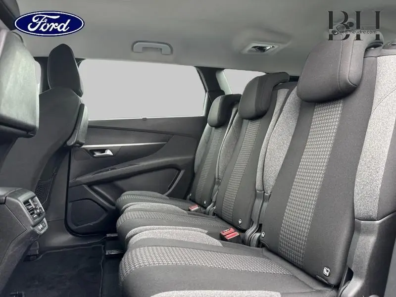 Vue latérale intérieure des sièges arrière gris tissu du Peugeot 5008, montrant la banquette 3 places et appuis-tête.