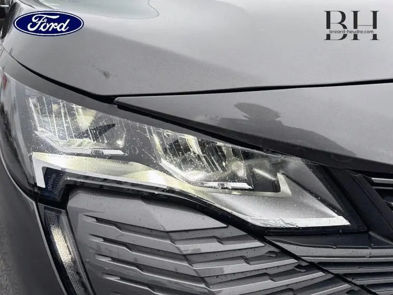 Gros plan sur le phare avant droit gris Platinium du Peugeot 5008 avec calandre et détails chromés.