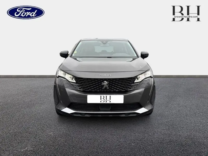 Vue frontale d'un Peugeot 5008 gris Platinium avec calandre noire et phares LED distinctifs.
