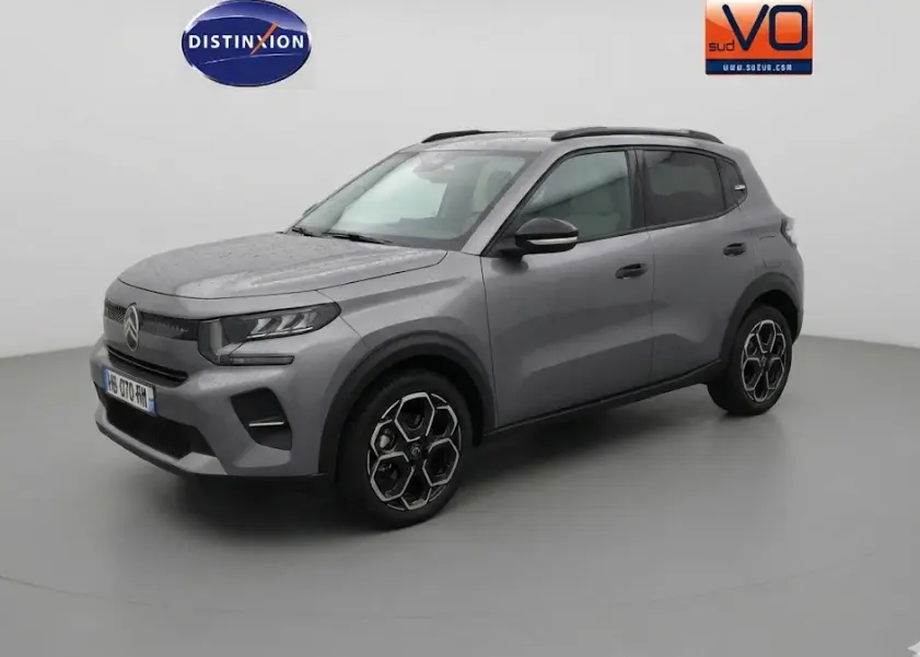 Vue 3/4 avant droit d'une Citroën C3 gris métallisé avec barres de toit et jantes alliage 17 pouces.