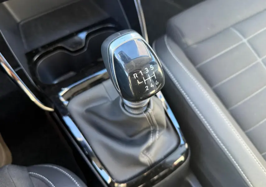 Gros plan sur le levier de vitesses manuel noir et la console centrale du Citroën C3 gris, intérieur moderne et soigné.