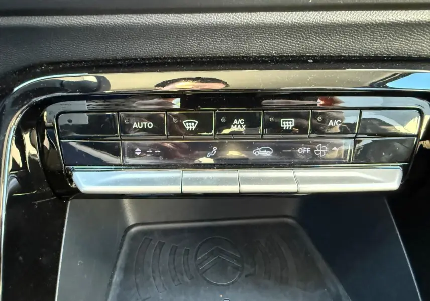 Vue rapprochée de la console centrale noire du Citroën C3 gris 2025, mettant en valeur les commandes de climatisation automatique.
