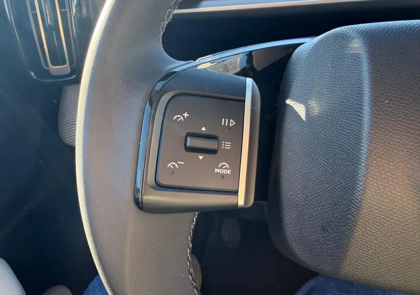 Gros plan sur les commandes de régulateur de vitesse au volant cuir noir de la Citroën C3 gris 2025.