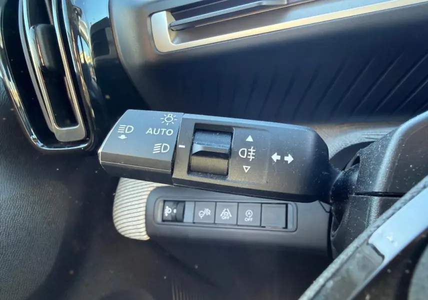 Gros plan sur la commande des feux et clignotants côté gauche du tableau de bord d'une Citroën C3 gris 2025.