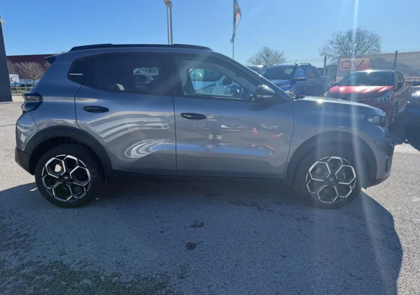 Profil côté gauche d'une Citroën C3 gris métallisé 2025 avec barres de toit et jantes alliage 17 pouces.