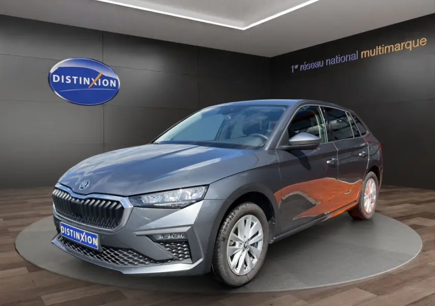 Vue 3/4 avant droite d'une Skoda Scala gris foncé exposée en showroom avec calandre noire distinctive.