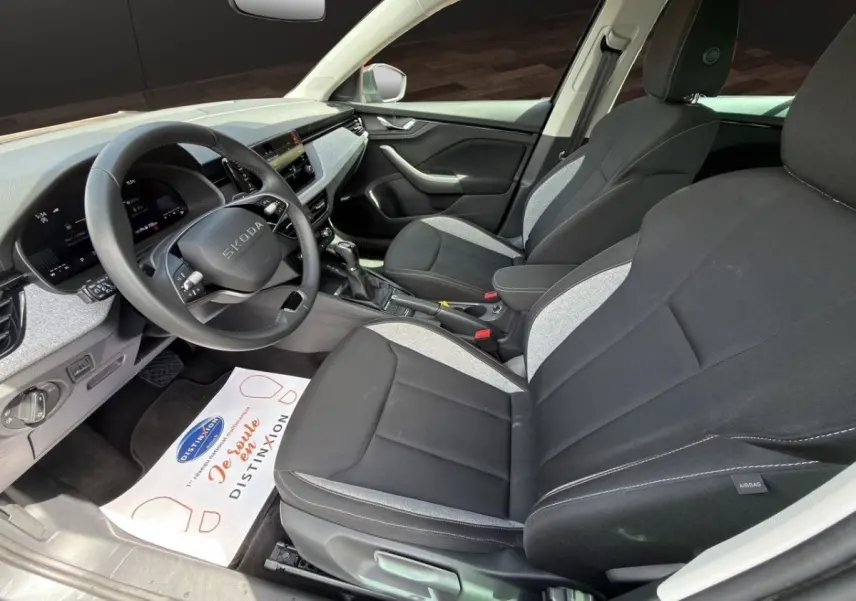 Vue intérieure côté conducteur de la Skoda Scala 2025 gris foncé, avec sièges bicolores et tableau de bord digital.