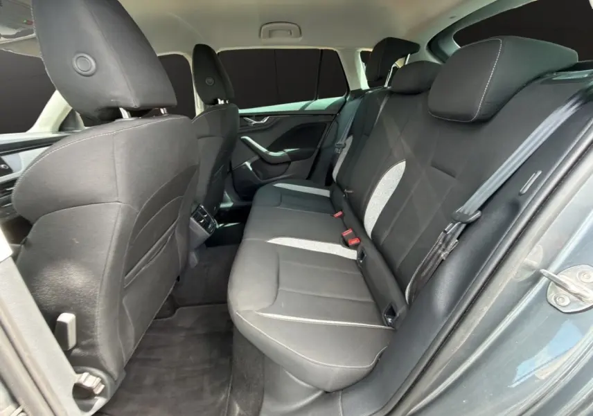 Vue intérieure arrière côté droit de la Skoda Scala gris foncé, montrant la banquette tissu noire avec inserts gris clair.