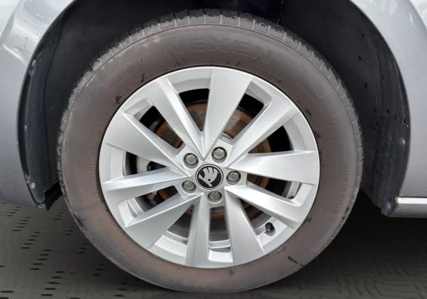Gros plan sur la roue avant gauche grise d’une Skoda Scala 2025 avec jante alliage et logo central noir.