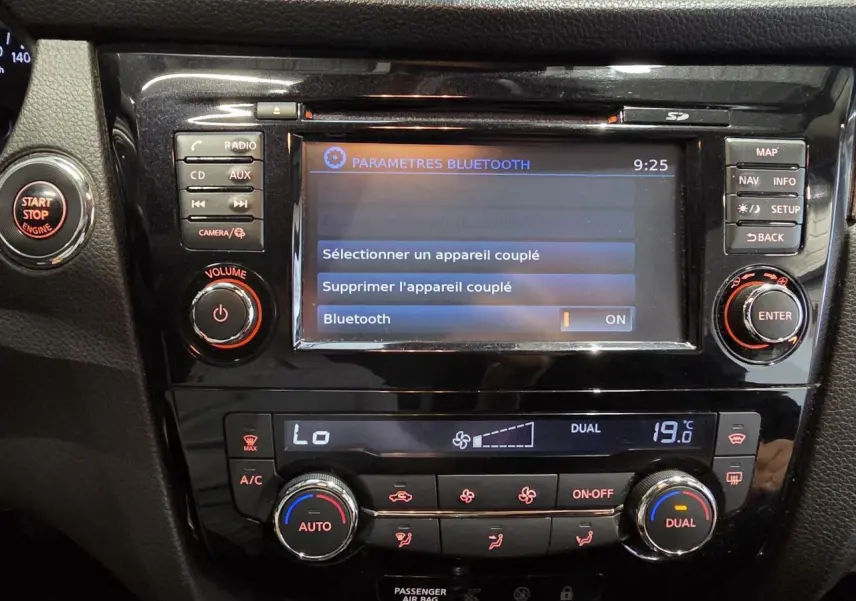 Vue rapprochée de la console centrale noire du Nissan Qashqai 2018 avec écran tactile et commandes climatisation.