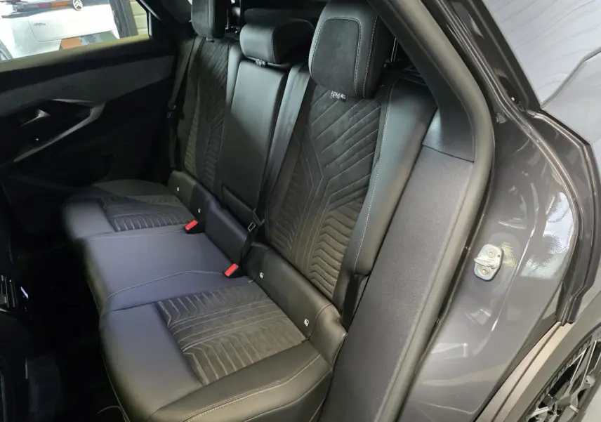 Vue intérieure côté droit des sièges arrière en cuir noir avec surpiqûres du Peugeot 3008 gris titanium 2026 GT Exclusive.