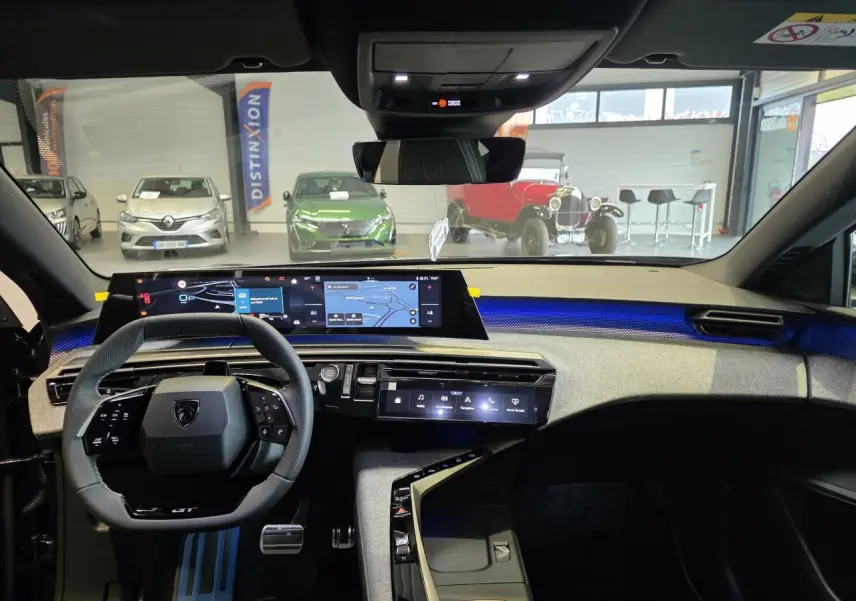 Vue intérieure du tableau de bord du Peugeot 3008 gris titanium 2026, avec écran numérique panoramique et éclairage d'ambiance bleu.