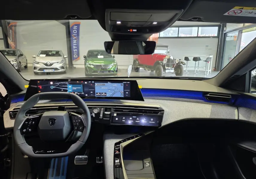 Vue intérieure du tableau de bord du Peugeot 3008 gris titanium 2026, avec écran tactile panoramique et éclairage d'ambiance bleu.