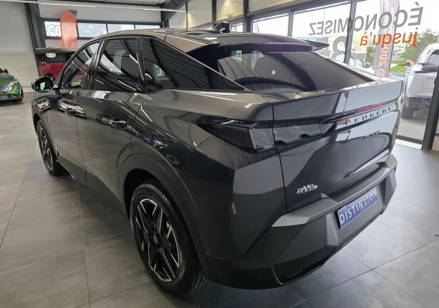 Vue 3/4 arrière droite du Peugeot 3008 gris titanium 2026 en hybride essence, avec feux arrière noirs et jantes noires.