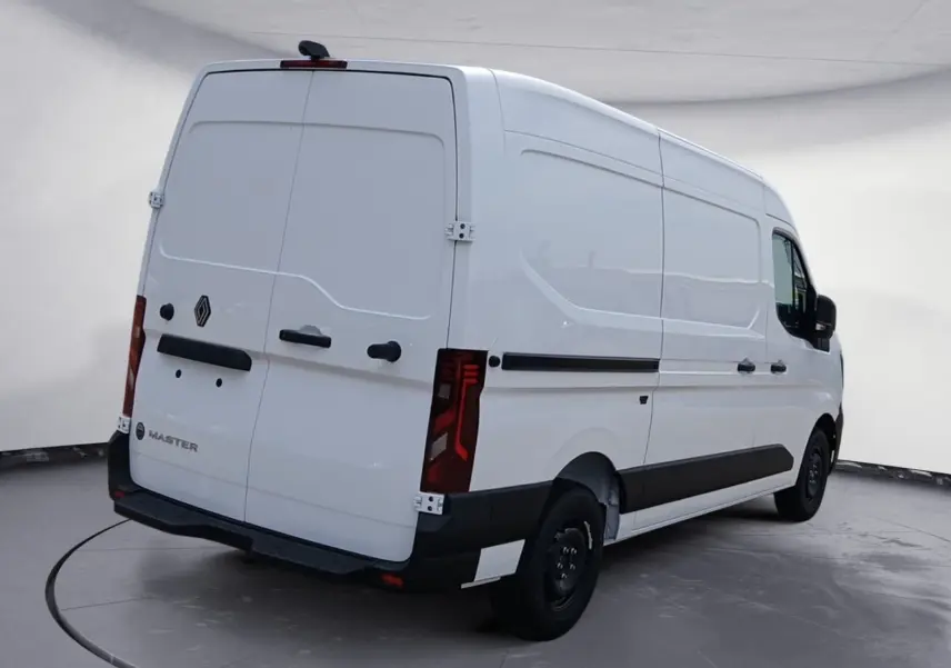 Vue 3/4 arrière droite d’un utilitaire Renault Master blanc avec portes arrière fermées et feux arrière allongés.